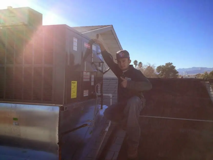 HVAC technician performing Air Duct Cleaning on a rooftop unit in Brecksville