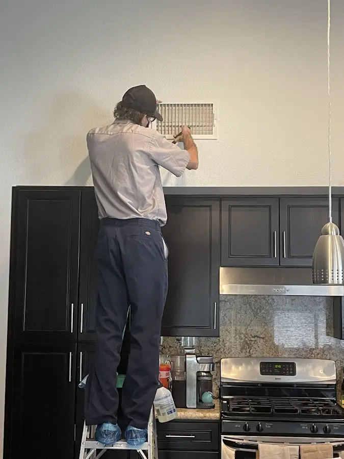 Technician inspecting an air vent during HVAC service in Brecksville